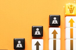 scrabble tiles increasing in scale with an upward arrow demonstrating success