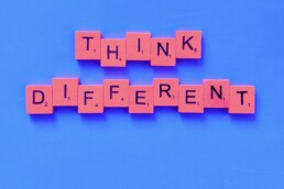 Think different spelt out using scrabble letters on a blue background