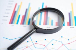 A magnifying-glass-on top of -charts on graph-paper